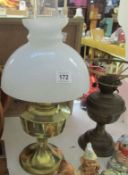A brass oil lamp with shade and chimney and one other
