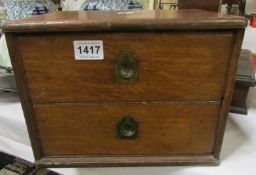 A small 2 drawer oak collector's cabinet with military handles