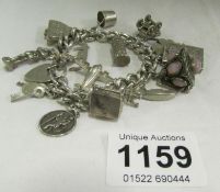 A silver charm bracelet with silver charms, 102gms