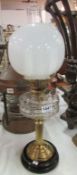 An oil lamp on pot base and with glass font and shade