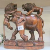 A carved wood elephant being attacked by lions
