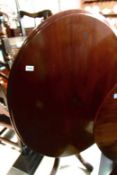 An oval mahogany tip top table