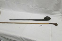 An old wooden club and a walking stick with leather handle