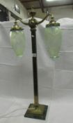 A twin light tall brass table lamp with acid etched vaseline glass shades (1 shade chipped on rim)