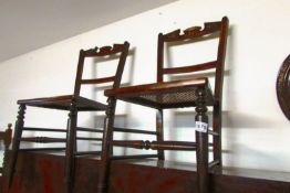 A pair of bedroom chairs with cane seats