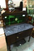 A marble topped washstand with tiled back