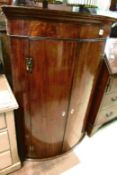 A Victorian mahogany bow front corner cupboard