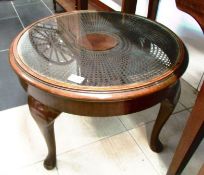 A circular glass topped coffee table