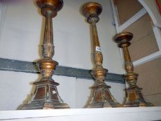 A set of 3 graduated gilded candlesticks