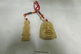 A carved Buddha head and small figure