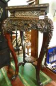 An ornate carved mahogany stand