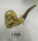 An Oriental pipe with the bowl in the shape of a skull