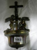 A Victorian brass crucifix with holy water font