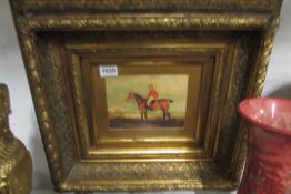 A gilt framed painting of a horse and hunter