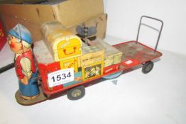 A tinplate clockwork railway station platform trolley with figure and luggage