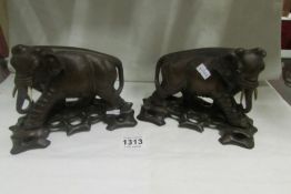 A pair of carved elephants on stands (1a/f)