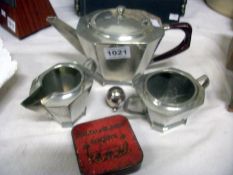 A 3 piece hammered pewter deco style tea set, a Mappin & Webb pepper pot and a Huntley and Palmers