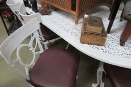 A large cast metal white garden table and 6 chairs