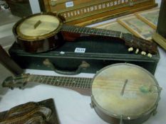 A cased banjoelle and a banjo