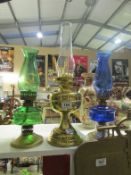A brass oil lamp and 2 glass and metal oil lamps