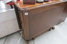 A drop leaf table with end drawer and cupboard