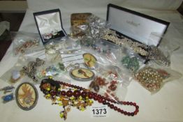 A box of costume jewellery inc amber necklace, brooches etc