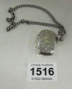 A silver vesta case and a watch chain