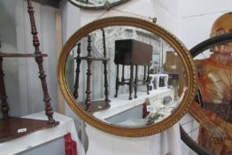 A gilt framed oval bevel edged mirror