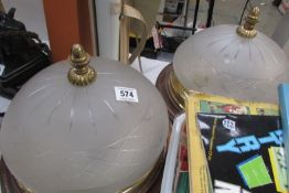 A pair of cut and frosted glass ceiling lights