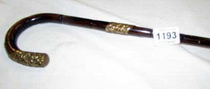 A walking cane with ornate collar and ferrulle