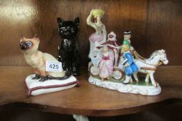 A black cat, cat on cushion, cinderella coach and figurine