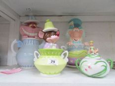 A Disney Cheshire cat teapot and Mad Hatter, Dormouse and Tinkerbell sugar bowls
