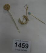 A gold hat pin, stick pin and crescent brooch set seed pearls