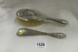 A silver backed hair brush and a silver handled shoe horn