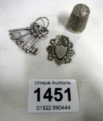 4 silver keys, a silver fob and a silver thimble