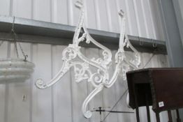 A pair of white cast metal bench ends