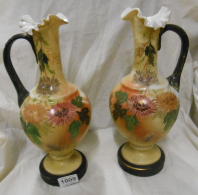 A pair of Victorian hand painted glass ewers