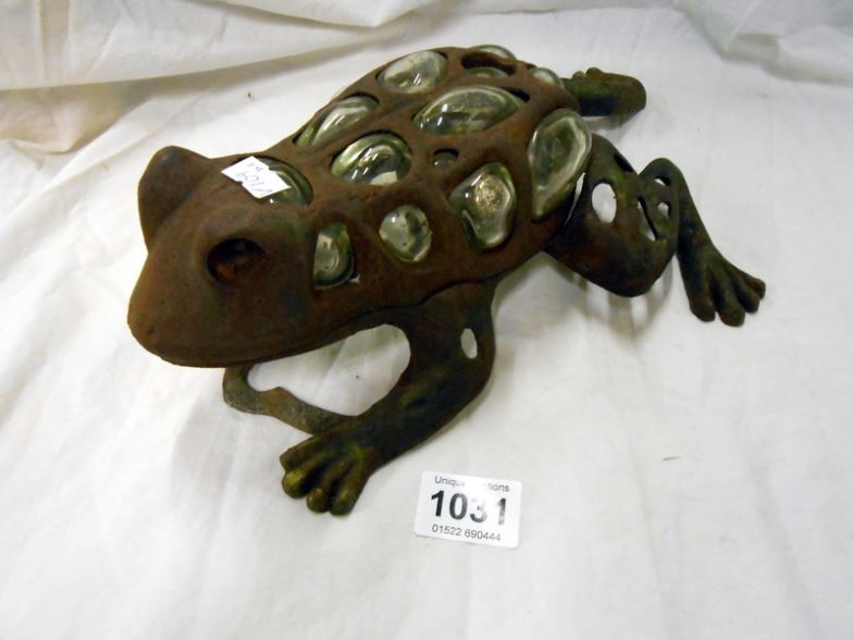 A glass and cast iron frog tea light