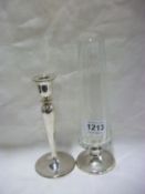 A silver candlestick and glass vase with silver foot