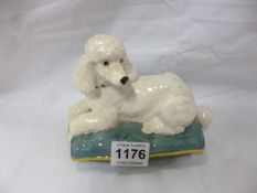 A Beswick poodle reclining on a cushion