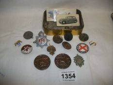 A tin of old badges and bronze medals