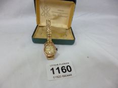 A 9ct gold ladies wristwatch on base metal bracelet