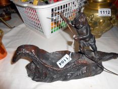 A Bronze figure of a boy on a dugout boat