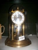 A Kundo anniversary clock under glass dome