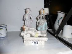 2 bisque figurines and a reclinging cherub figure