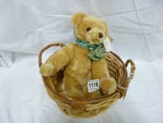 A Merrythought bear in basket signed by Oliver Holmes
