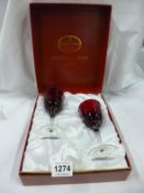 A cased pair of John Jenkins Imperial ruby wine glasses