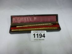 A cased Edwardian brass twist dip pen and pencil