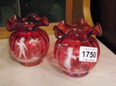 A pair of cranberry glass vases with Mary Gregory style design