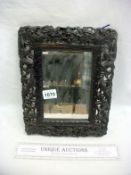 An Oriental carved wood mirror